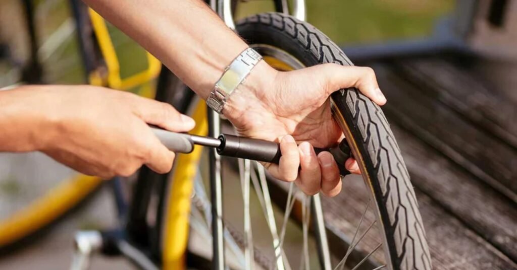 Cyclist inspecting tire pressure, brakes, and drivetrain before a long-distance ride.