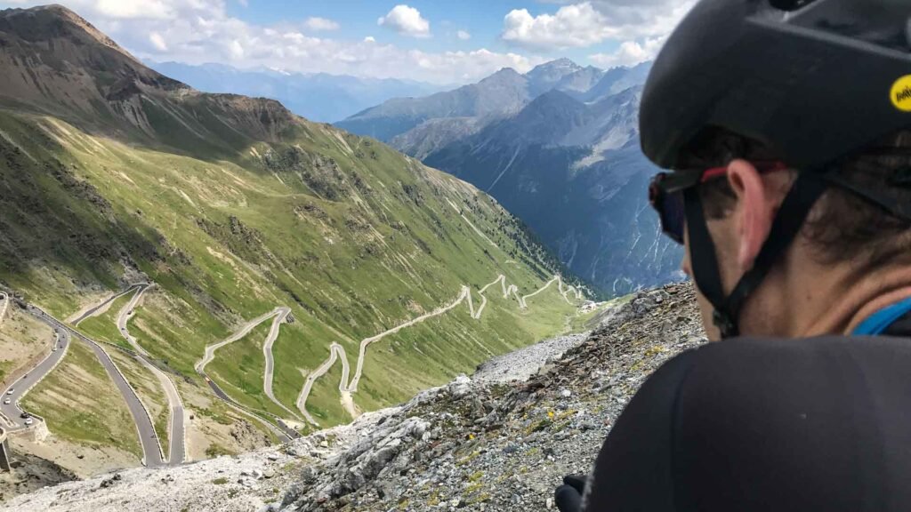 Cyclist climbing the Stelvio Pass with stunning Alpine views